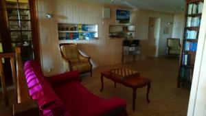 uma sala de estar com um sofá vermelho e uma mesa em la ferme du crie em Chaudeyrolles
