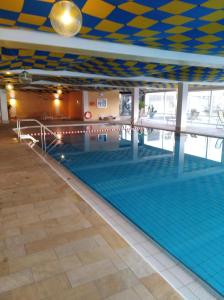 a large swimming pool with a blue and yellow ceiling at Rosenalm App 23 in Scheidegg