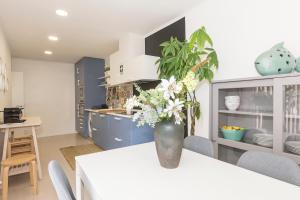 a kitchen with a table with a vase of flowers on it at OrangeTreeHouses in Montijo