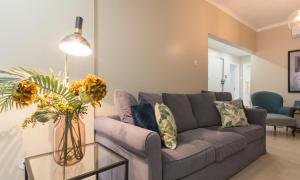 a living room with a gray couch and a glass table at OrangeTreeHouses in Montijo