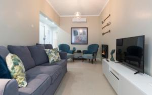 a living room with a blue couch and a flat screen tv at OrangeTreeHouses in Montijo