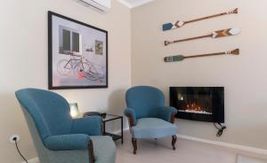 a living room with two chairs and a fireplace at OrangeTreeHouses in Montijo