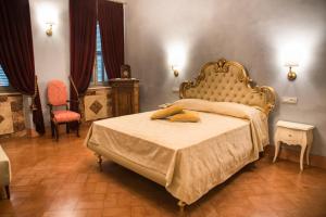 um quarto com uma cama grande com uma moldura dourada em PALAZZO ILLUMINATI em Ripatransone