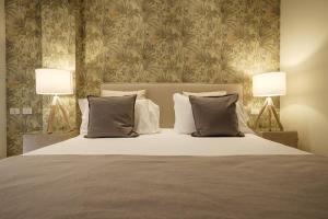 Residence Lungomare - Charming apartments في ريتشيوني: غرفة نوم بسرير كبير فيها مصباحين