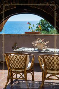 una mesa y sillas con vistas al océano en B&B La Torretta, en Maratea