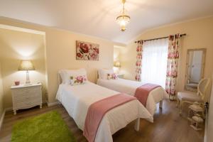 a bedroom with two beds and a window at Sete Cidades Quinta Da Queiró in Sete Cidades