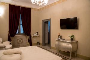 a bedroom with a bed and a television on the wall at PALAZZO ILLUMINATI in Ripatransone