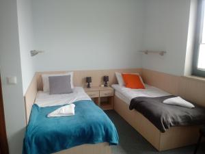 dwa łóżka siedzące obok siebie w pokoju w obiekcie Hostel Załogowa w Gdańsku