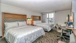 a hotel room with two beds and a desk at Holiday Inn Resort Oceanfront at Surfside Beach, an IHG Hotel in Myrtle Beach