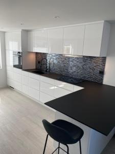 a kitchen with white cabinets and a black counter top at Årostunet 3 in Søgne