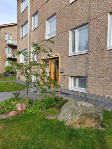 a building with a rock in front of a building at Tina's Place in Pori