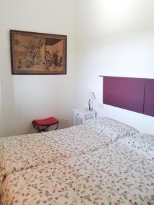 sypialnia z łóżkiem i obrazem na ścianie w obiekcie Casa Rural La Aulaga w mieście El Castillo de las Guardas +36 zdjęć