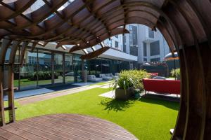 an outdoor area with a wooden pergola and grass at BessaHotel Baixa in Porto