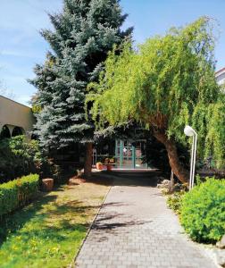 une promenade avec un arbre et un bâtiment dans l'établissement Motel Vega, à Sezimovo Ústí