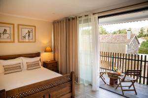 a bedroom with a bed and a balcony at Sete Cidades Quinta Da Queiró in Sete Cidades