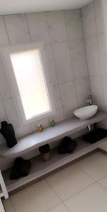 a bathroom with a sink and a window at Le cosy de sarah in Bordeaux-Saint-Clair