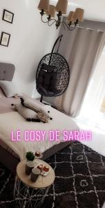 a bedroom with a bed with a table and a chair at Le cosy de sarah in Bordeaux-Saint-Clair