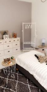 a bedroom with a white bed and a table at Le cosy de sarah in Bordeaux-Saint-Clair
