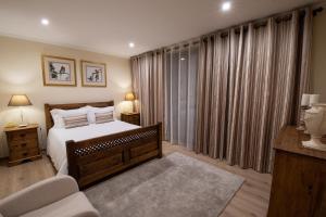 a bedroom with a bed and a window with curtains at Sete Cidades Quinta Da Queiró in Sete Cidades