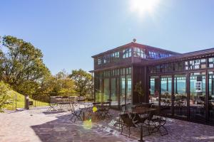 a large glass building with tables and chairs at Sächsische Bildungs- und Begegnungsstätte Windmühle Seifhennersdorf in Seifhennersdorf