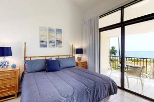 a bedroom with a blue bed and a balcony at Beach Villa 233 in Humacao