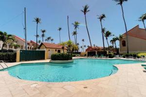 a large swimming pool in a resort with palm trees at Beach Villa 233 in Humacao