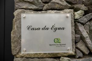 a sign for a restaurant on a stone wall at Sete Cidades Quinta Da Queiró in Sete Cidades