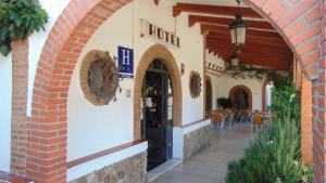 un arco que conduce a un restaurante con mesa y sillas en El Mesón de Despeñaperros, en Santa Elena