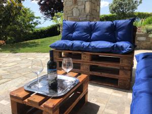 a bench with a bottle of wine and two glasses on a table at La Casa Blu in Montegrosso dʼAsti