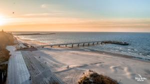 z powietrza widok na plażę z molo w obiekcie Apartamenty Bałtycka6 w Kołobrzegu