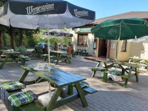 grupa stołów piknikowych z parasolami w obiekcie Ferienwohnung "Am Schlosspark" w mieście Neetzow