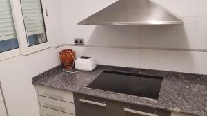 - une cuisine avec un comptoir, un évier et une cuisinière dans l'établissement Apartamento Céntrico, à Peñíscola