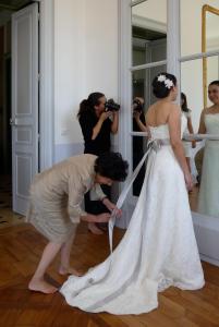 Eine Braut, die ihr Kleid vor einem Spiegel anpasst. in der Unterkunft La Grande Maison in Seine-Port
