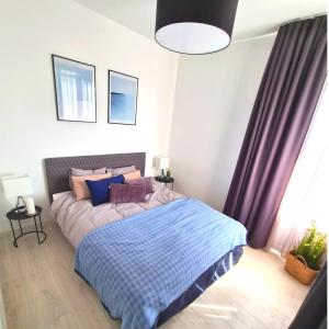 AZURE PREMIUM KOŁOBRZEG في كولوبرزيغ: غرفة نوم مع سرير وبطانية زرقاء