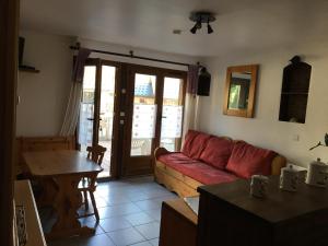 a living room with a red couch and a table at Chez polyte in Bourg-Saint-Maurice