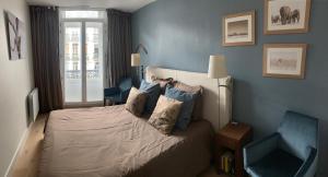 a bedroom with a bed with blue walls and a window at Paddy's Place in Lille