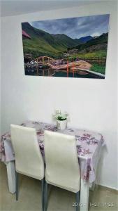a table with two chairs and a picture of a bridge at Yair room apartment in Jerusalem