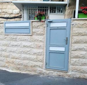 ein Gebäude mit einer blauen Tür und einem Fenster in der Unterkunft Yair room apartment in Jerusalem