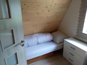 uma pequena cama no canto de uma pequena casa em Naše chatka pod Strání em Rožnov pod Radhoštěm