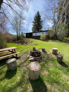 a fire pit in a field with logs and a bench at Rolling R Guest Ranch in Meeker