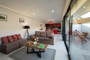 a living room with two couches and a table at Sete Cidades Quinta Da Queiró in Sete Cidades