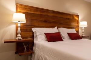 a bedroom with a bed with a wooden headboard and two lamps at Sete Cidades Quinta Da Queiró in Sete Cidades