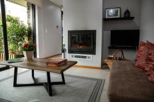 a living room with a coffee table and a fireplace at Sete Cidades Quinta Da Queiró in Sete Cidades