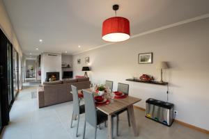 a dining room and living room with a table and chairs at Sete Cidades Quinta Da Queiró in Sete Cidades