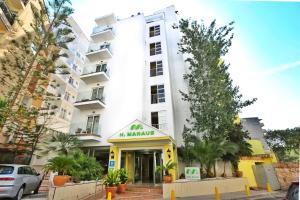 duży biały budynek z szyldem przed nim w obiekcie Hotel Manaus w El Arenal
