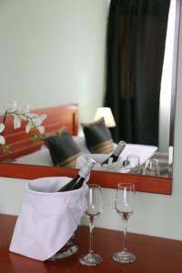 a table with two glasses and a bottle of wine at Hotel Apollonia in Prishtinë
