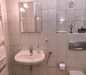 a white bathroom with a sink and a mirror at Ferienwohnung Sächsische Schweiz in Bielatal