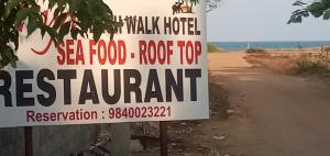 ein Schild für ein Restaurant auf einer unbefestigten Straße in der Unterkunft Meya Beach Walk Hotel in Mahabalipuram