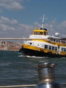 un gran barco blanco y amarillo en el agua en Casa do Rio - Riverside House, en Seixal