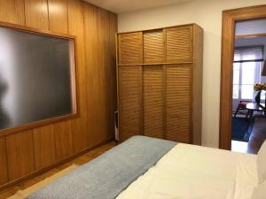 a bedroom with a large flat screen tv and a bed at Casa do Rio - Riverside House in Seixal